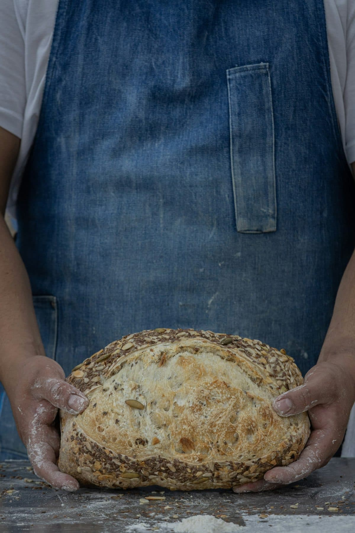 A baker holding a fresh loaf